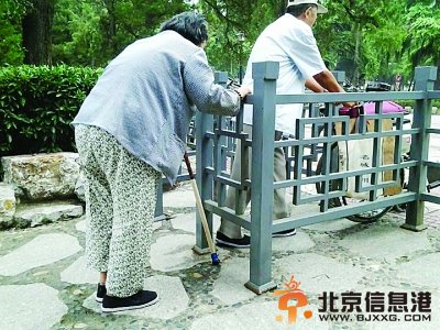 網友拍攝的兩位老人艱難通過公園小門。